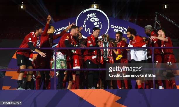 Jurgen Klopp, Adam Lallana and Mohamed Salah of Liverpool hold the Premier League Trophy as they celebrate winning the League Title during the...