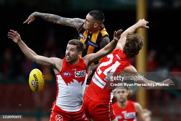 Chad Wingard of the Hawks is challenged by Jake Lloyd and Dane Rampe of the Sydney Swans during the round 8 AFL match between the Sydney Swans and...