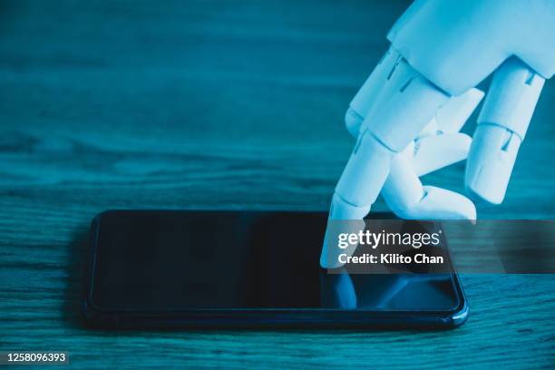 robotic hand using phone (concept of ai tapping into personal data privacy) - android phone stock pictures, royalty-free photos & images