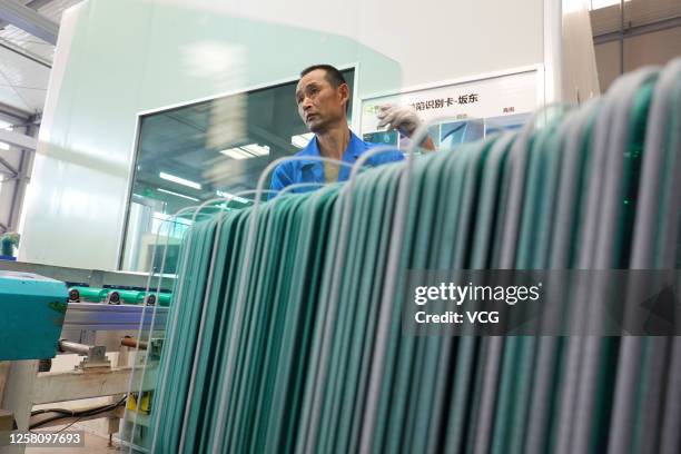 An employee works on the production line of auto wind shields at a workshop of Ming Chi Glass Co., Ltd on July 24, 2020 in Weihai, Shandong Province...