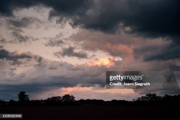 dramatischer himmel beim sonnenuntergang - dramatischer himmel stock pictures, royalty-free photos & images