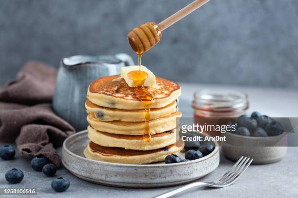 fluffy buttermilk blueberry pancakes with honey - pancakes stockfoto's en -beelden