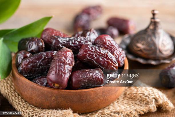 dried medjool dates in wooden bowl - date fruit stock pictures, royalty-free photos & images