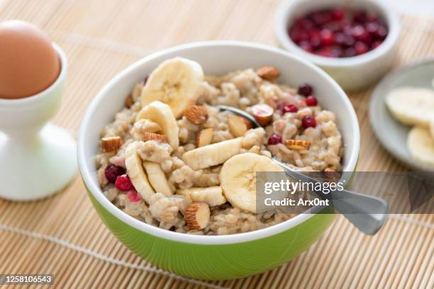 oatmeal porridge with banana, almonds - haferflocken stock-fotos und bilder