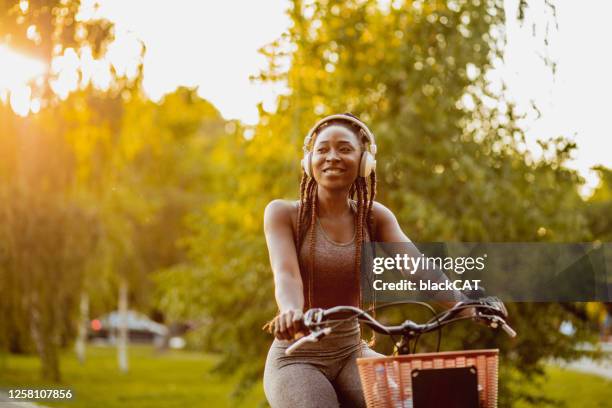 modern woman on a bike ride in nature - black woman riding bike stock pictures, royalty-free photos & images