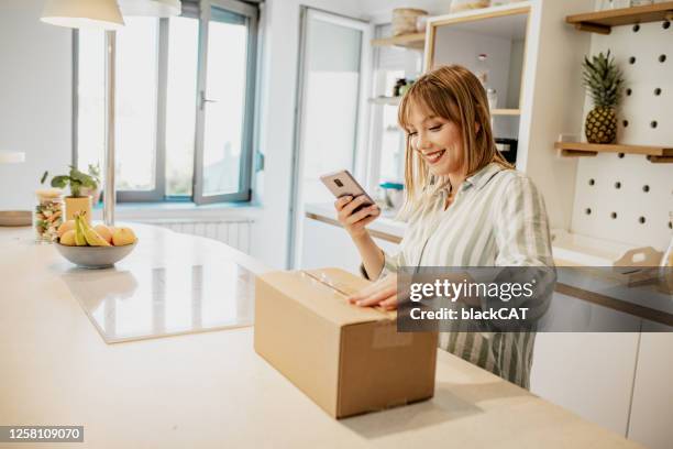 junge frau macht ein foto von dem paket, das sie online bestellt - online shopping opening package stock-fotos und bilder