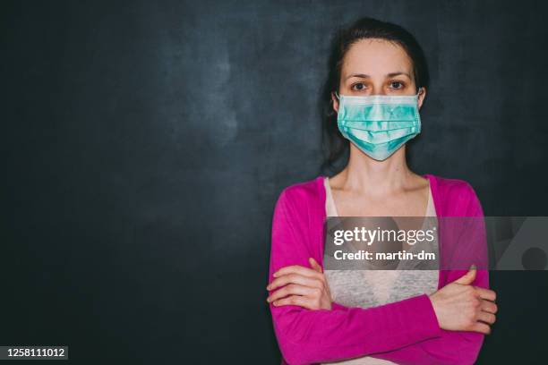 woman wearing protective face mask during covid-19 pandemic - woman black background stock pictures, royalty-free photos & images