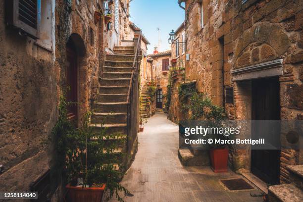 stone houses in old etruscan village, tuscany, italy - village foto e immagini stock