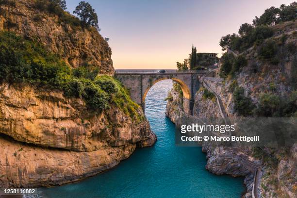 the stone arch bridge of the furore fjord, amalfi coast, italy - costa caratteristica costiera foto e immagini stock