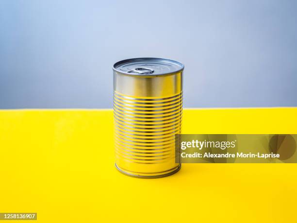 silver can on a yellow background - canned goods stock-fotos und bilder