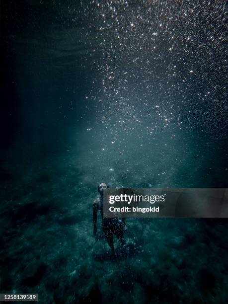 man floating underwater - man underwater stock pictures, royalty-free photos & images