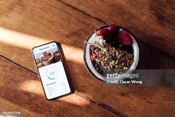 starting your day with a healthy vegan breakfast - smart phone on table stock pictures, royalty-free photos & images