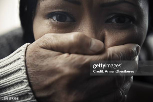 scared woman with maniac hand over her mouth - women being strangled foto e immagini stock