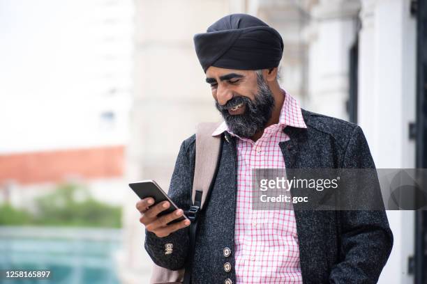 silk businessman with turban using smart phone - punjab stock pictures, royalty-free photos & images
