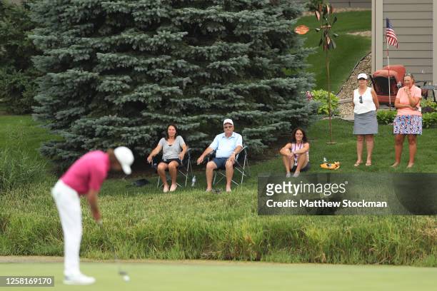 Spectators watch from their backyard as Aaron Baddeley of Australia putts on the sixth green during the third round of the 3M Open on July 25, 2020...