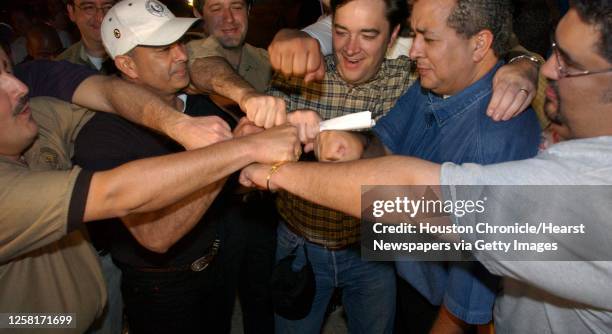 Crowd gathers around Rep. Jim Dunnam of Waco in celebration at a rest stop just inside the Texas border, Thursday night, May 15, 2003. The group of...