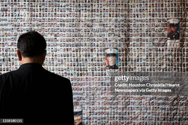 Ray Massa of Baytown pauses as he looks at the faces on a quilt that memorialize service men and women who've died in Iraq and Afghanistan at the...