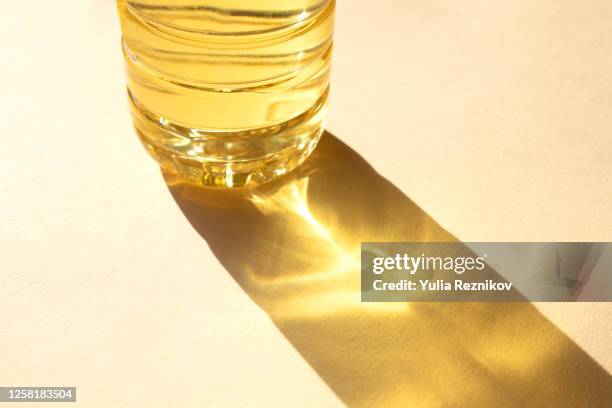 bottle of sunflower oil on the beige background - light reflection stock-fotos und bilder