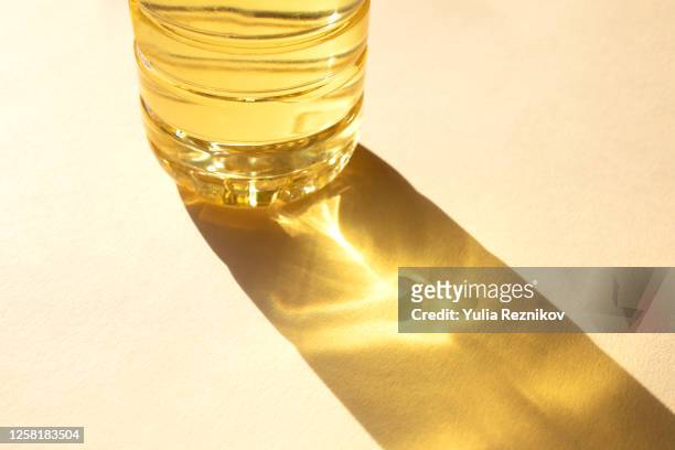 bottle of sunflower oil on the beige background - reflection photos et images de collection