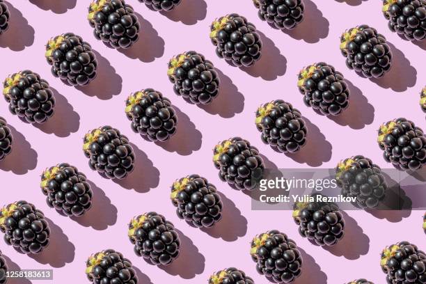repeated blackberries on the purple background - blackberry foto e immagini stock