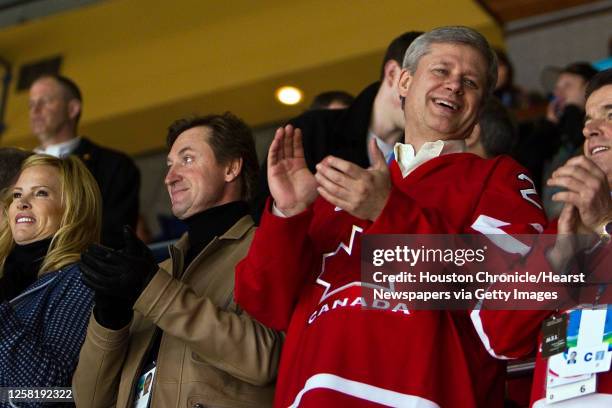 Canadian Prime Minister Stephen Harper applauds a first period goal along side hockey great Wayne Gretzky as Canada defeats the USA in the women's...