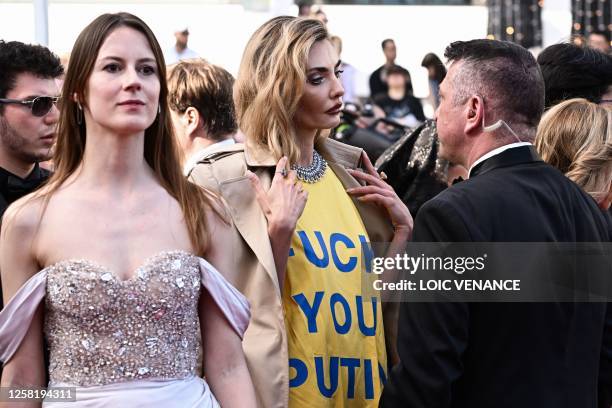 Ukrainian model Alina Baikova , wearing a t-shirt bearing the colours of the Ukrainian flag, talks with security as she arrives for the screening of...