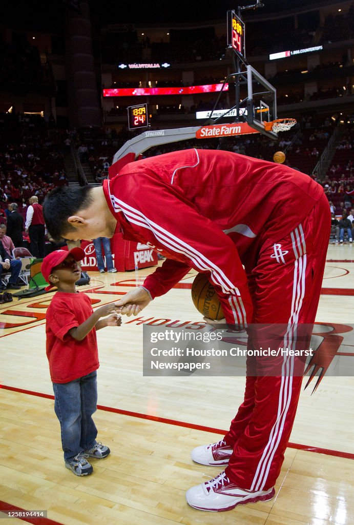 Houston Rockets center Yao Ming shakes hands with three-year-old Noah