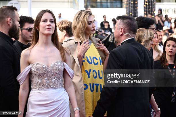 Ukrainian model Alina Baikova , wearing a t-shirt bearing the colours of the Ukrainian flag, talks with security as she arrives for the screening of...