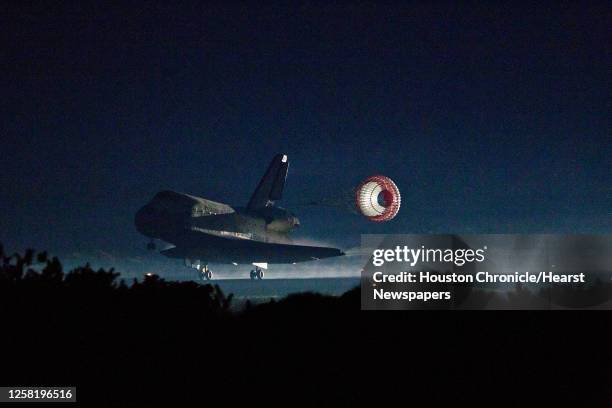 The drag chute is deployed as the space shuttle Atlantis lands at the Kennedy Space Center in Florida completing STS-135, the final mission of the...