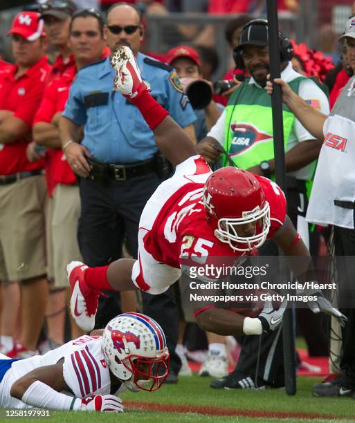 Houston running back Bryce Beall is upended by SMU defensive back Richard Crawford during the first half in an NCAA football game at Robertson...