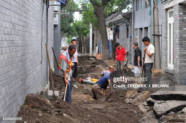 China-culture-history-beijing by Robert J. Saiget A construction crew dig up a street undergoing renovations near Nanluoguxiang, an area surrounded...