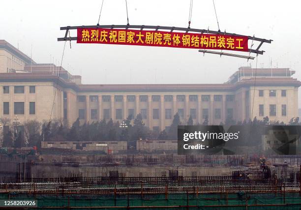 The last roof beam is prepared to be laid at the construction site of the National Grand Theatre, with the background of the Great Hall of the...