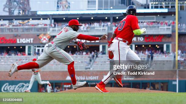 Marcell Ozuna of the Atlanta Braves is tagged out in a rundown by Josh Harrison of the Philadelphia Phillies during the second inning at Truist Park...
