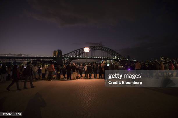 People wait near Sydney Harbour Bridge during the opening day of Vivid Sydney in Sydney, Australia, on Friday, May 26, 2023. The annual winter...