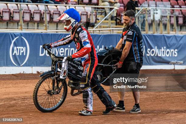 Freddy Hodder and his father carry the failed bike off the track after the heat. The clutch had failed during the National Development League match...
