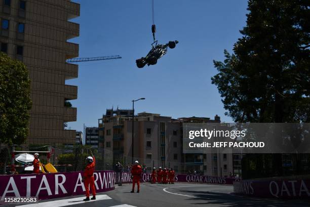 Race marshals remove the car of Mercedes' British driver Lewis Hamilton from the track after he crashed during the third practice session of the...