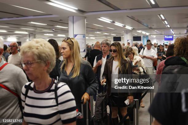 Passengers queue at Gatwick Airport as electronic passport gates fail across the UK on May 27, 2023 in Crawley, England. Passengers arriving at...