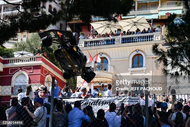 Spectators watch as the car of Red Bull Racing's Mexican driver Sergio Perez is removed from the track after he crashed during a qualifying session...