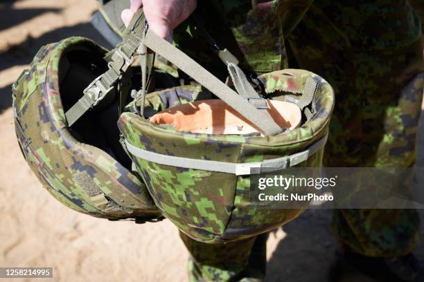 Kevlar helmets are seen held by a soldier during a training exercise near Tapa, Estonia on 20 May, 2023. Estonia is hosting the Spring Storm NATO...