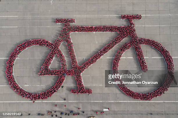 People gather during an attempt to break the Guinness World record for the largest human bicycle on May 27, 2023 in Santiago, Chile.