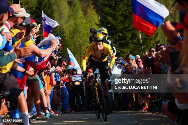 Spectators cheer as Jumbo-Visma's Slovenian rider Primoz Roglic competes on his way to win the twentieth stage and take the overall lead of the Giro...