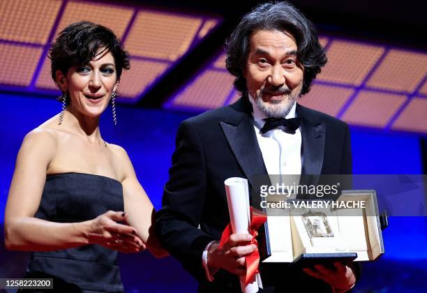 Japanese actor Koji Yakusho poses on stage with Iranian actress Zar Amir-Ebrahimi after he won the Best Actor Prize for his part in the film "Perfect...