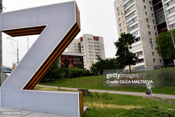 Woman walks past the giant Z letter, a tactical insignia of Russian troops in Ukraine, in the Russian city of Belgorod, some 40 km from border with...