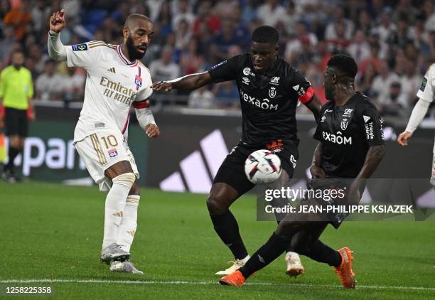 Lyon's French forward Alexandre Lacazette fights for the ball with Reims' Zimbabwean midfielder Marshall Munetsi during the French L1 football match...