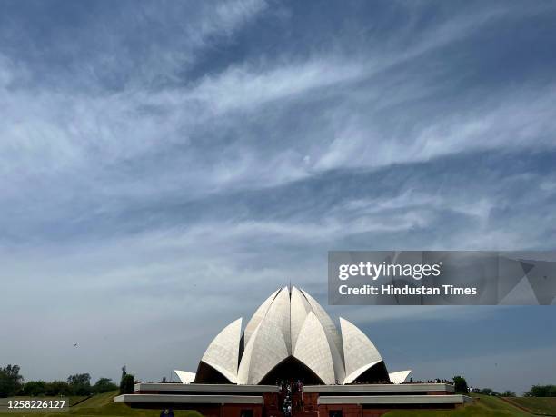 People visit Lotus Temple, after rain under cloudy shades, on May 27, 2023 in New Delhi, India.