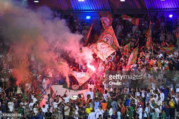Ettifaq's supporters light flares in the stands during the Saudi Pro League football match between Al-Nassr and Al-Ettifaq at the Prince Mohammed Bin...