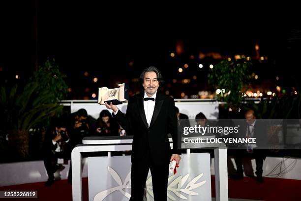 Japanese actor Koji Yakusho poses with his trophy during a photocall after he won the Best Actor Prize for his part in the film "Perfect Days" during...