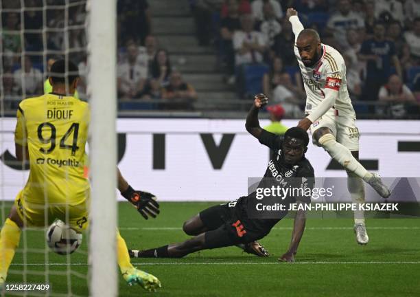 Lyon's French forward Alexandre Lacazette scores a goal past Reims' French goalkeeper Yehvann Diouf during the French L1 football match between...