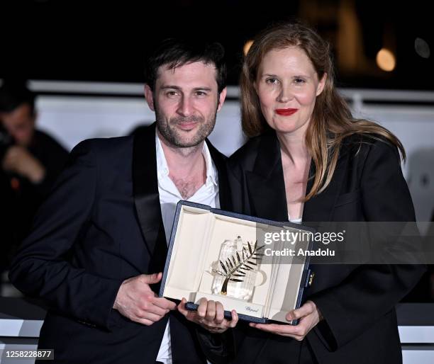 French director Justine Triet poses with her trophy with French actor and screenwriter Arthur Harari during a photocall after winning the Palme d'Or...