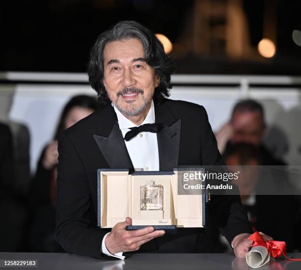 Japanese actor Koji Yakusho poses during a photocall with his trophy after winning the Best Actor Prize for his part in the film Perfect Days during...